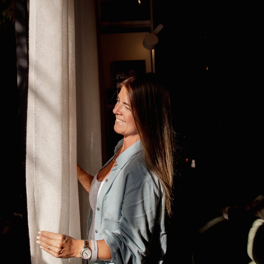 Luana Mattos abrindo uma cortina de linho
